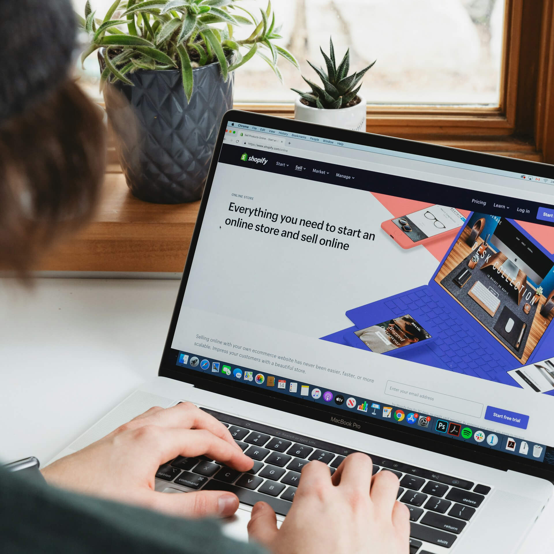 Person using a MacBook Pro with Shopify website open, showcasing tools to start an online store—ideal for promoting Shopify apps for eCommerce growth.